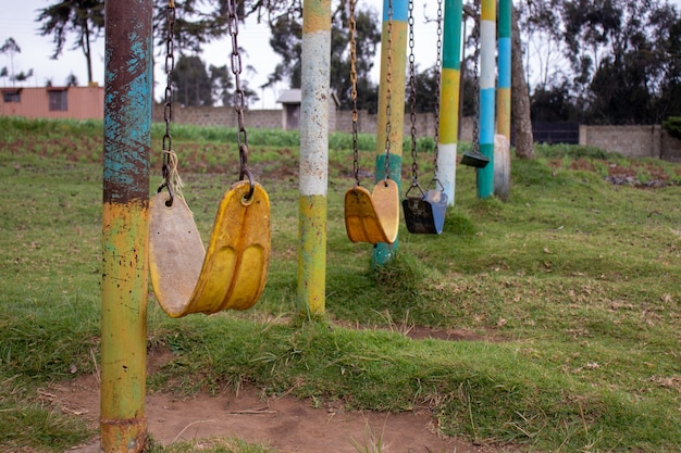 Parque con muchos columpios de cadenas desgastados