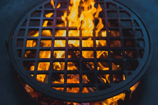 parrilla de la barbacoa, primer plano. cocinando profesionalmente comida en un fuego abierto sobre una rejilla de hierro fundido.