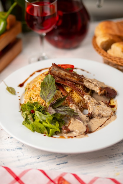 Parrilla de carne en salsa de crema de mantequilla servida con guarnición de arroz y ensalada verde.