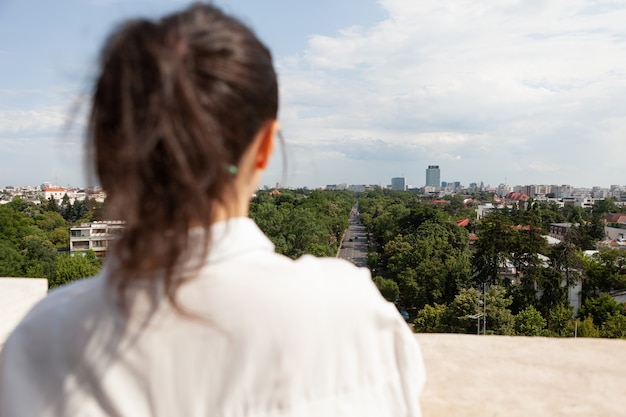 Parte delantera de la mujer caucásica toursit de pie en la terraza de la torre