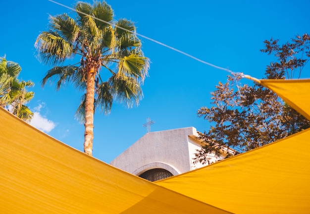 Foto gratuita la parte superior de la iglesia a través de decoraciones amarillas de la calle.