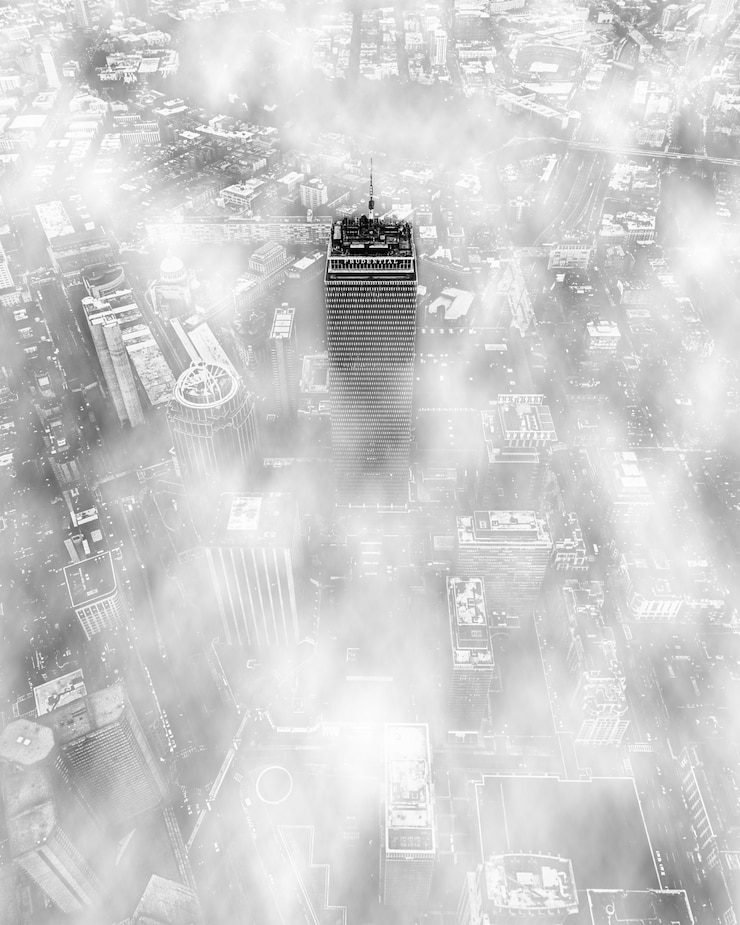 Foto gratuito la parte superior de un rascacielos rodeado de nubes