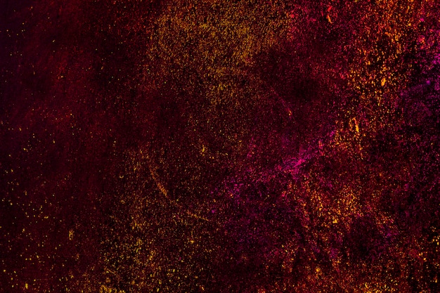 Partículas de polvo holi colorido sobre fondo negro