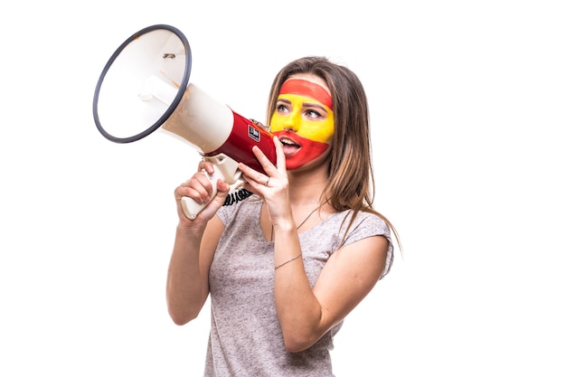 Partidario de la mujer, fanático leal del equipo nacional de España, la cara de la bandera pintada obtiene feliz victoria gritando en el megáfono con la mano puntiaguda. Fans de las emociones.