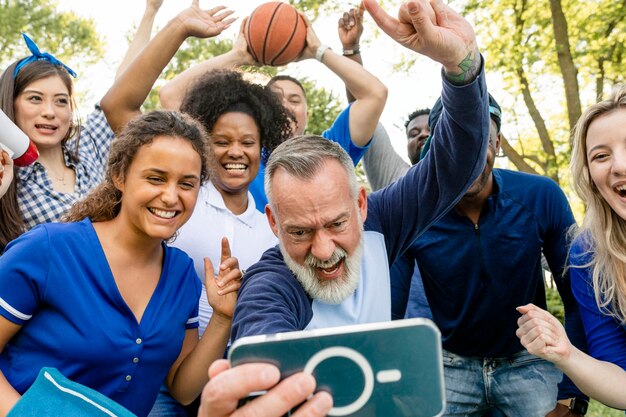 Partidarios de baloncesto viendo a su equipo ganar el juego en un teléfono móvil