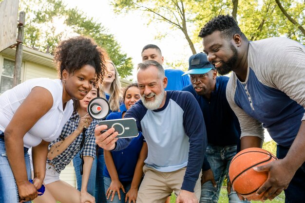 Partidarios de baloncesto viendo a su equipo ganar el juego en un teléfono móvil