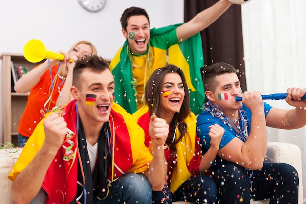 Partidarios del fútbol multinacional celebrando un gol