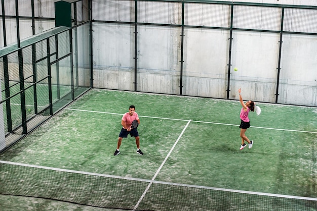 Foto gratuita partido de pádel mixto en una pista de pádel cubierta