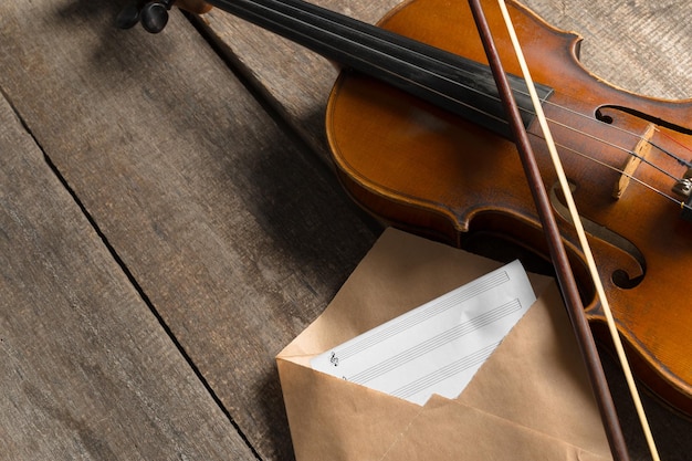 Partituras y violín en mesa de madera