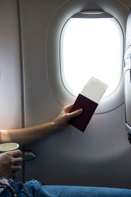 Foto gratuita pasaporte y boletos al lado de una ventana de avión