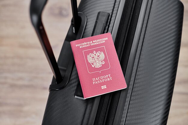Pasaporte ruso en una maleta de viaje negra vista superior antecedentes selectivos Emigración de rusos que buscan asilo