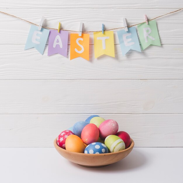 Pascua escribiendo sobre tazón con huevos