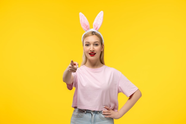 Pascua joven linda chica guapa con orejas de conejo apuntando al frente y sonriendo