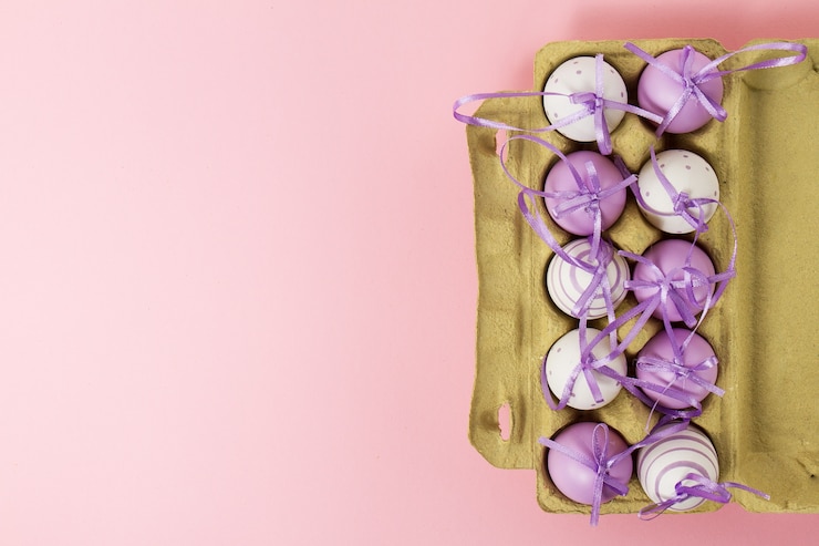 Foto gratuito pascua o primavera, concepto de la comida. huevos frescos en caja para huevos en fondo de color rosa pastel. vista superior.