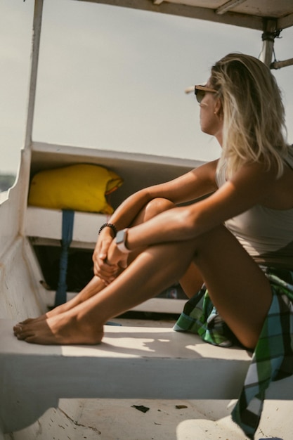 Paseo en barco en Bali. Una joven con gafas de sol navega en un barco hacia una isla cercana.