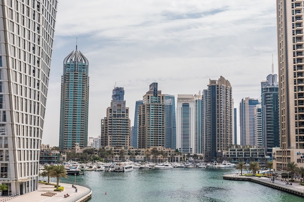 Paseo y canal en Dubai Marina con lujosos rascacielos alrededor, Emiratos Árabes Unidos.