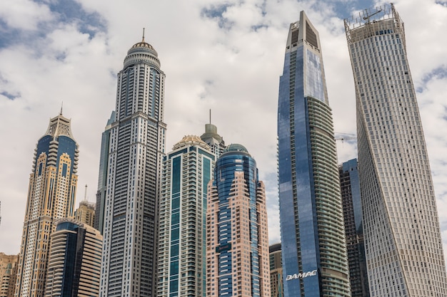 Paseo y canal en Dubai Marina con lujosos rascacielos alrededor, Emiratos Árabes Unidos.