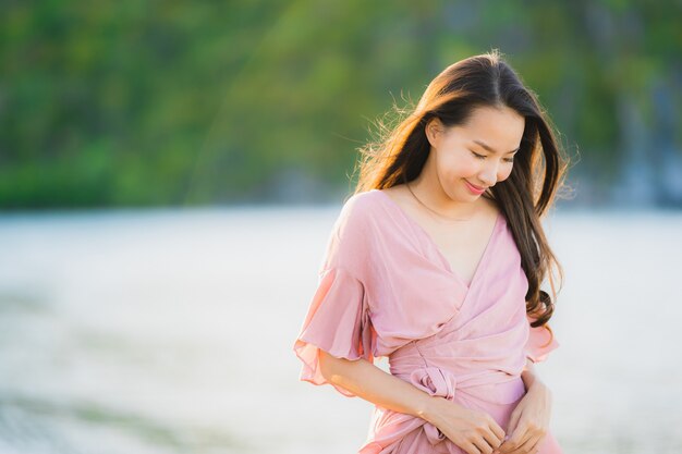 Paseo feliz de la sonrisa asiática joven hermosa de la mujer del retrato en el mar al aire libre tropical de la playa de la naturaleza