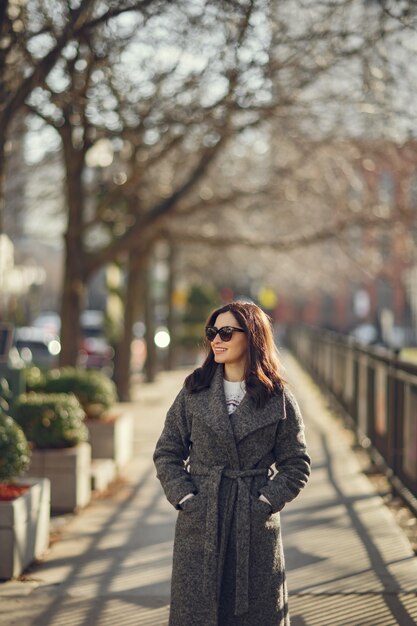 Paseo de la muchacha elegante en una ciudad de invierno.