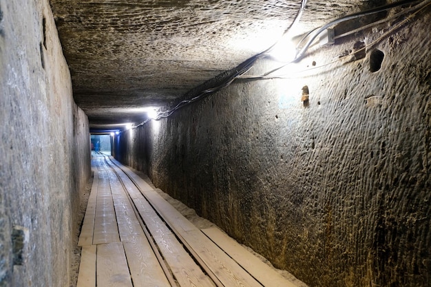 Pasillo de piedra extenso oscuro de una mina abandonada