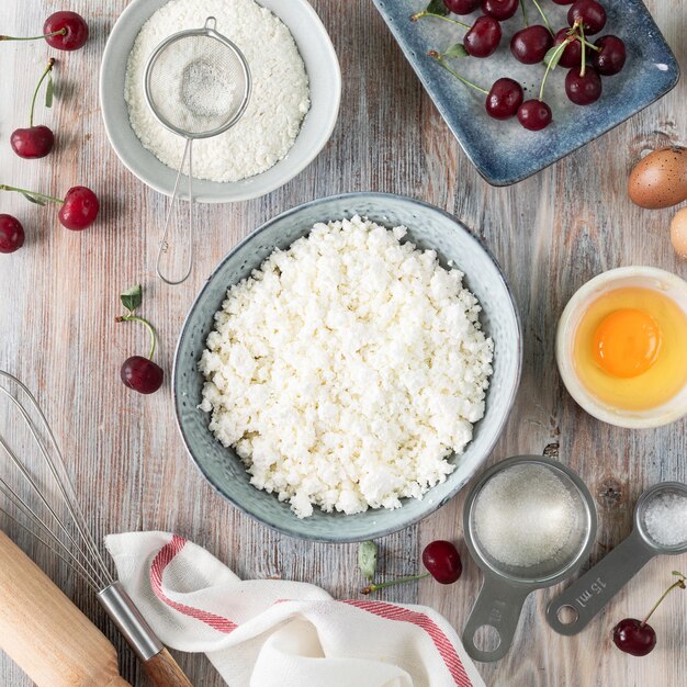 Paso 1 El proceso de cocinar albóndigas Albóndigas caseras de requesón con salsa de cereza sobre un fondo de madera Un plato tradicional ucraniano