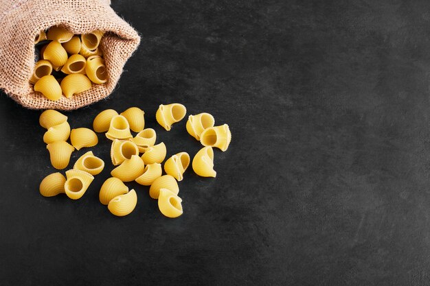 Pasta aislado en negro de un paquete de arpillera.