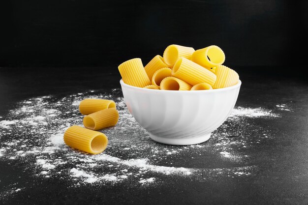 Pasta aislado en negro en una taza blanca.