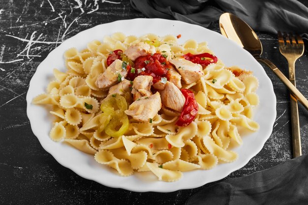 Pasta con chiles rojos en un plato blanco.