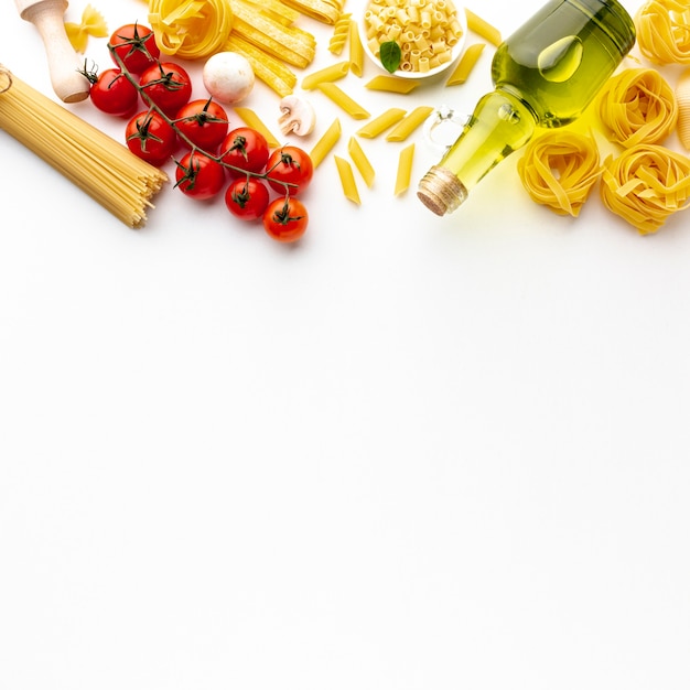 Pasta sin cocer de alto ángulo con tomates aceite de oliva y espacio de copia