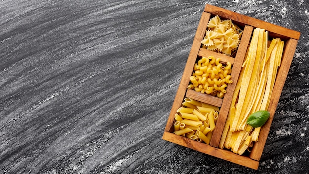 Pasta sin cocer en caja de madera con espacio de copia