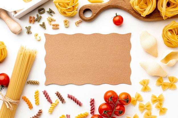 Foto gratuita pasta sin cocer mezcla tomates y queso duro con maqueta de cartón