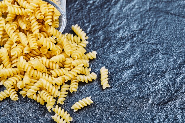 Pasta cruda dentro del frasco de vidrio en azul