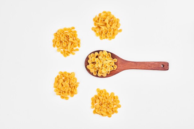 Pasta en una cuchara de madera sobre blanco