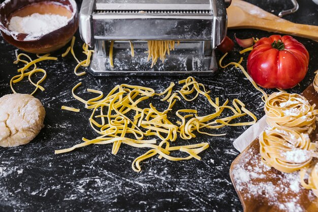 Pasta e ingredientes cerca de la máquina