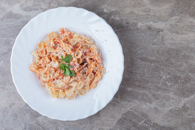 Pasta farfalle con boloñesa sobre el bol, sobre el mármol.