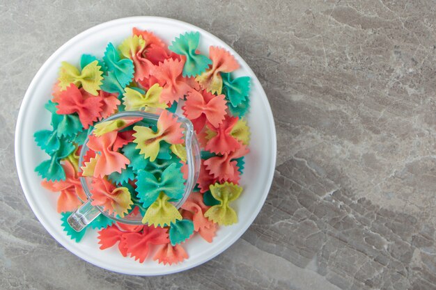 Pasta farfalle colorida en taza de vidrio