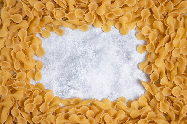 Pasta Farfalle seca sin cocer colocada sobre una mesa de mármol. Foto de alta calidad