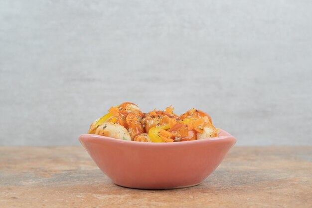 Pasta con forma de concha en un recipiente con salsa de tomate