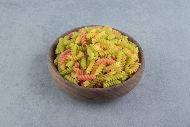 Foto gratuita pasta fusilli de colores en un tazón de madera.