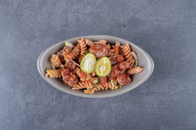 Pasta fusilli con pollo en cuenco de cerámica.