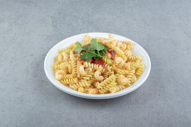 Pasta fusilli con salsa en un plato blanco.