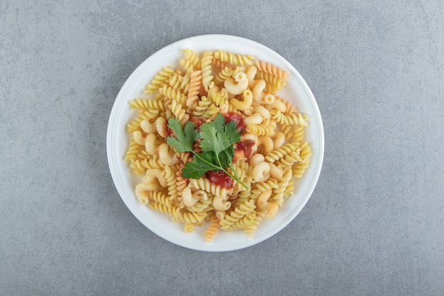 Foto gratuita pasta fusilli con salsa en un plato blanco.