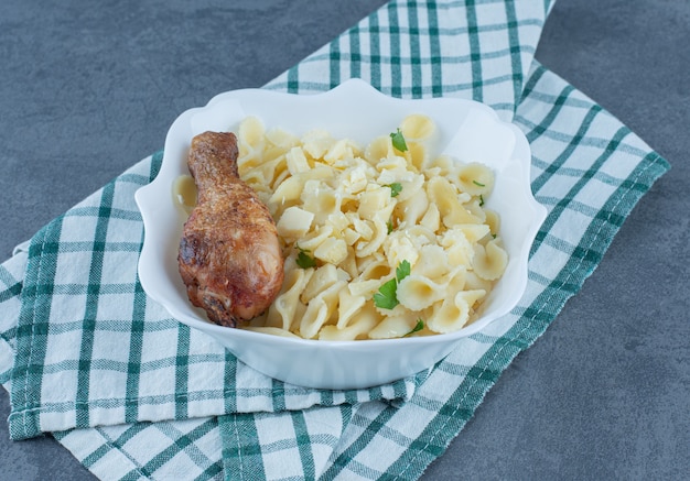 Foto gratuita pasta hervida con muslo de pollo en un tazón blanco.