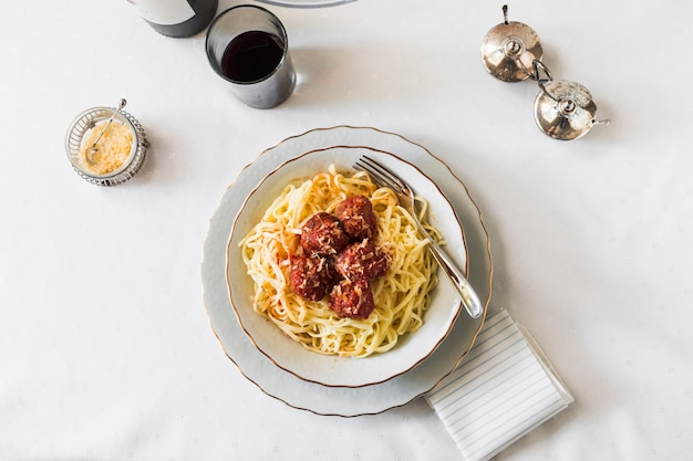 Pasta italiana con albóndigas en tazón de cerámica blanca