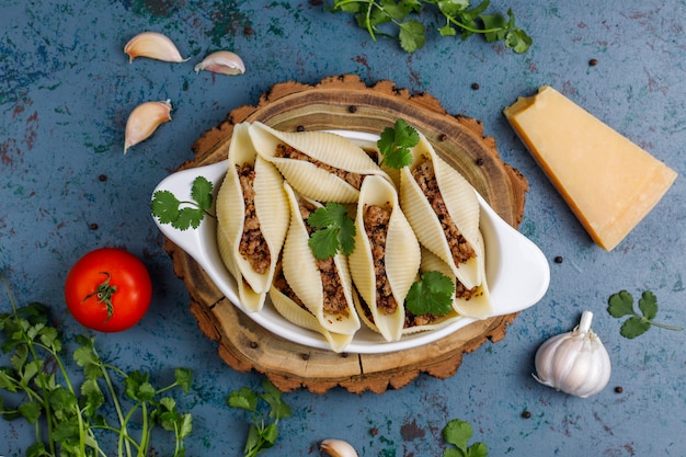 Foto gratuita pasta italiana conchiglioni rigati rellena de carne.