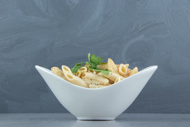 Pasta penne cremosa en un tazón blanco