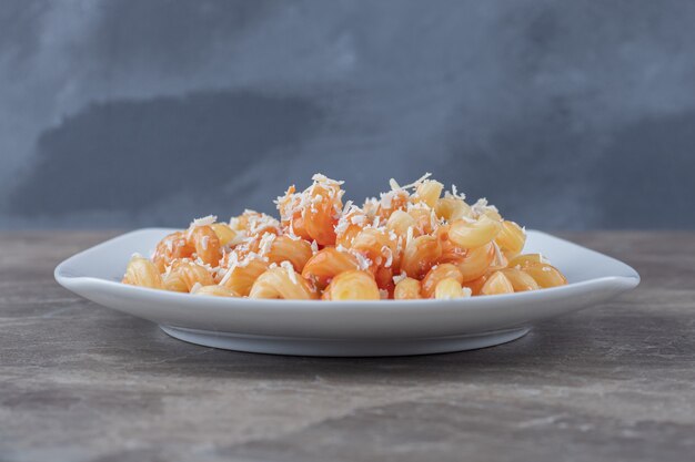 Pasta picante con salsa de tomate, sobre el mármol.