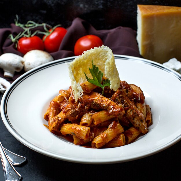 Pasta con pollo en salsa de tomate y queso rallado