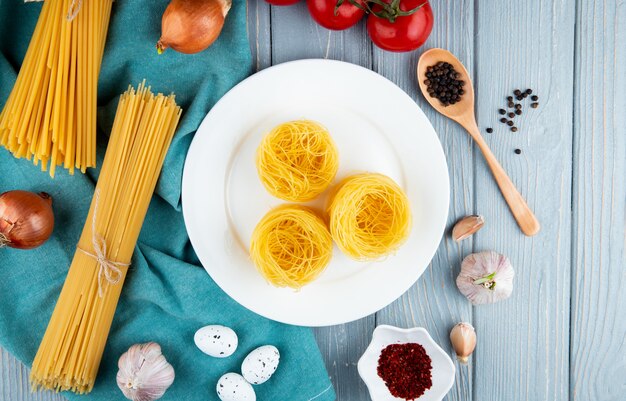 Pasta tagliolini en la placa blanca linguini espagueti huevos ajo cebolla vista superior