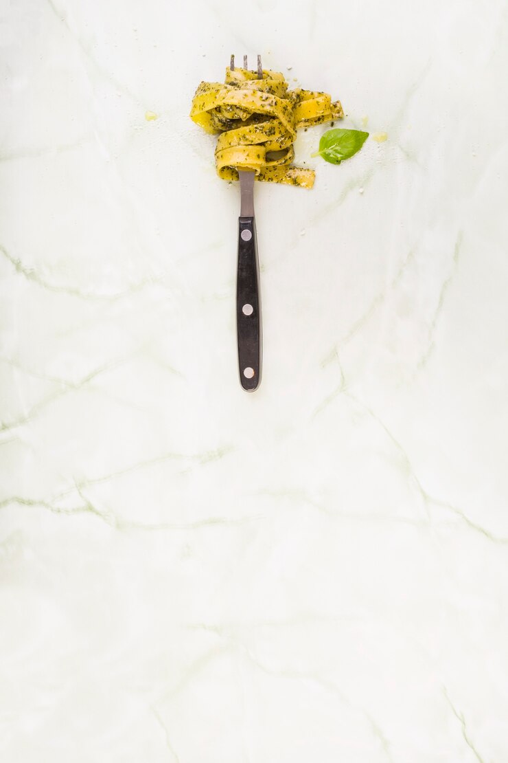 Foto gratuito pasta de tallarines enrollada en tenedor cerca de hoja verde